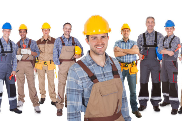 Portrait of happy construction worker with colleagues standing over white background
